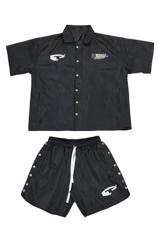 Black shirt and shorts set with logos on a gray surface